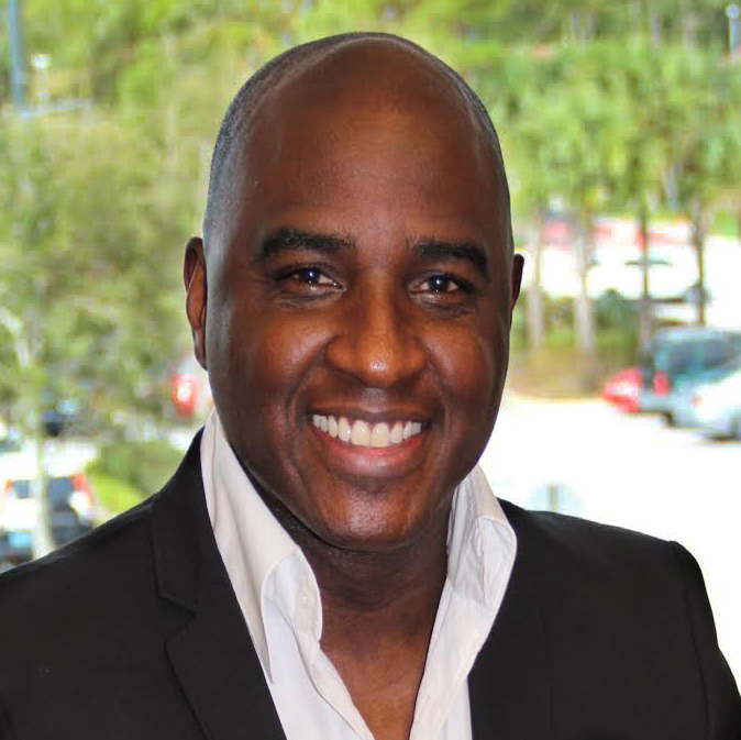 A man in a suit and tie smiling for the camera.