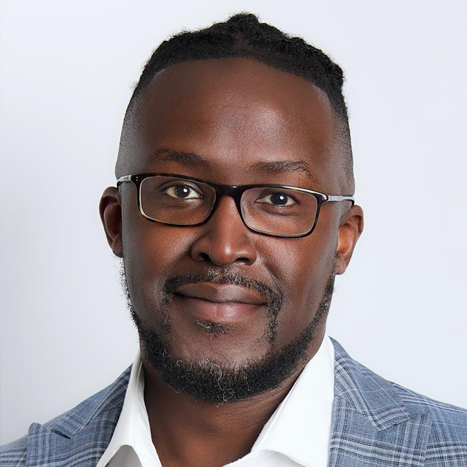 A man with glasses and a beard wearing a suit.